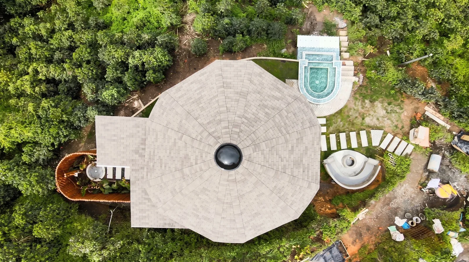 Vista cenital del techo octogonal del glamping entre el verde de la montaña
