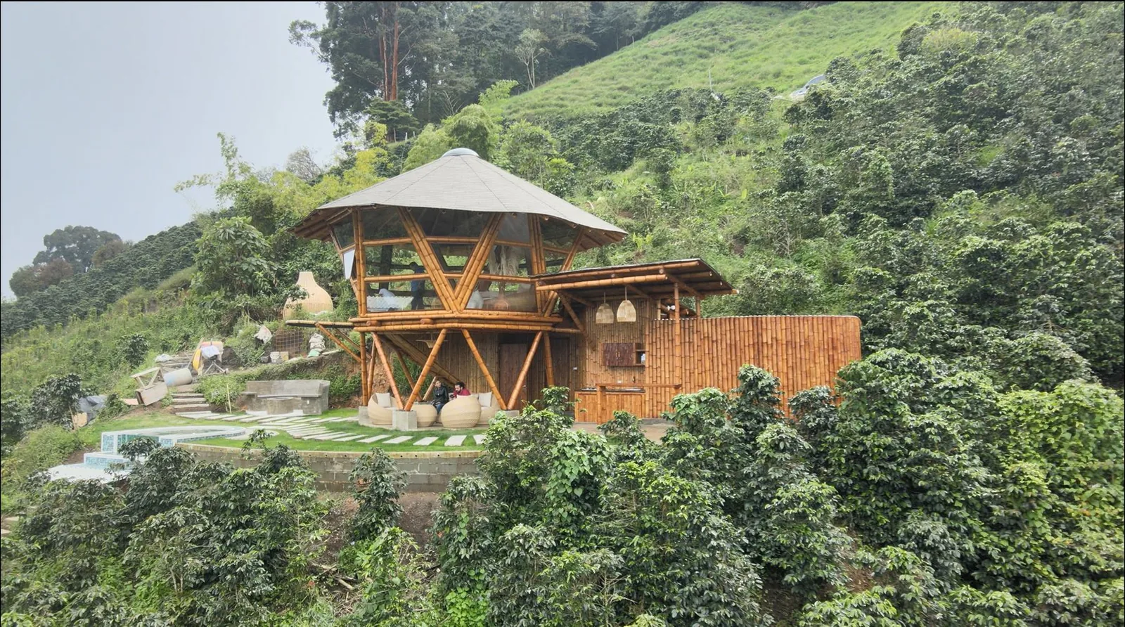 Cabaña de guadua terminada rodeada de cafetales, en la ladera de la montaña