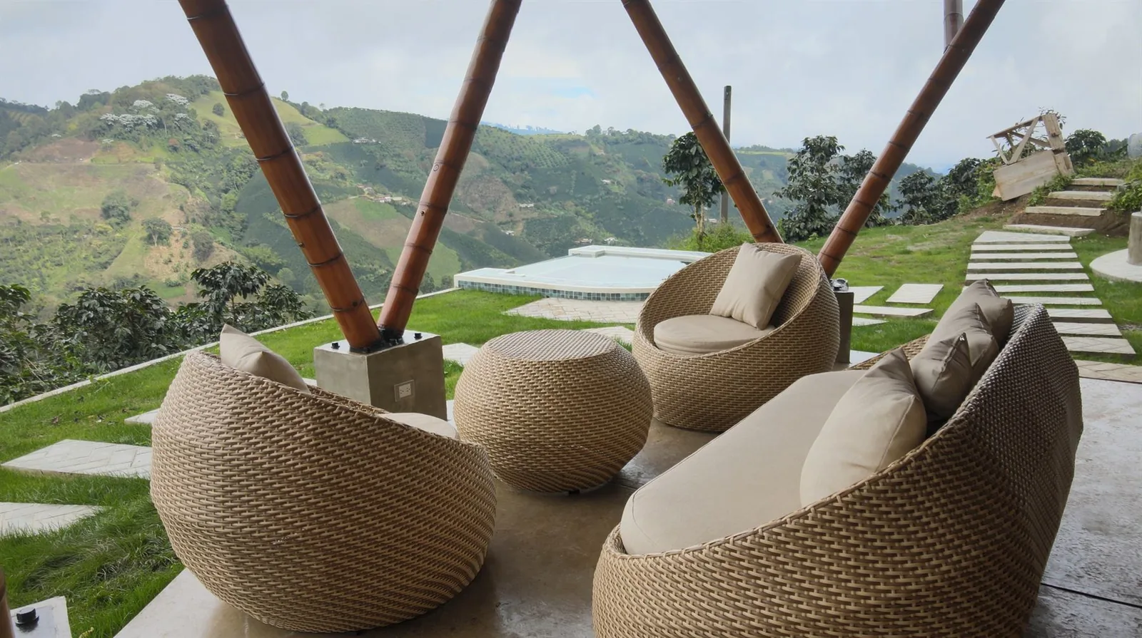 Terraza del glamping con muebles tejidos y vista abierta a las montañas cafeteras